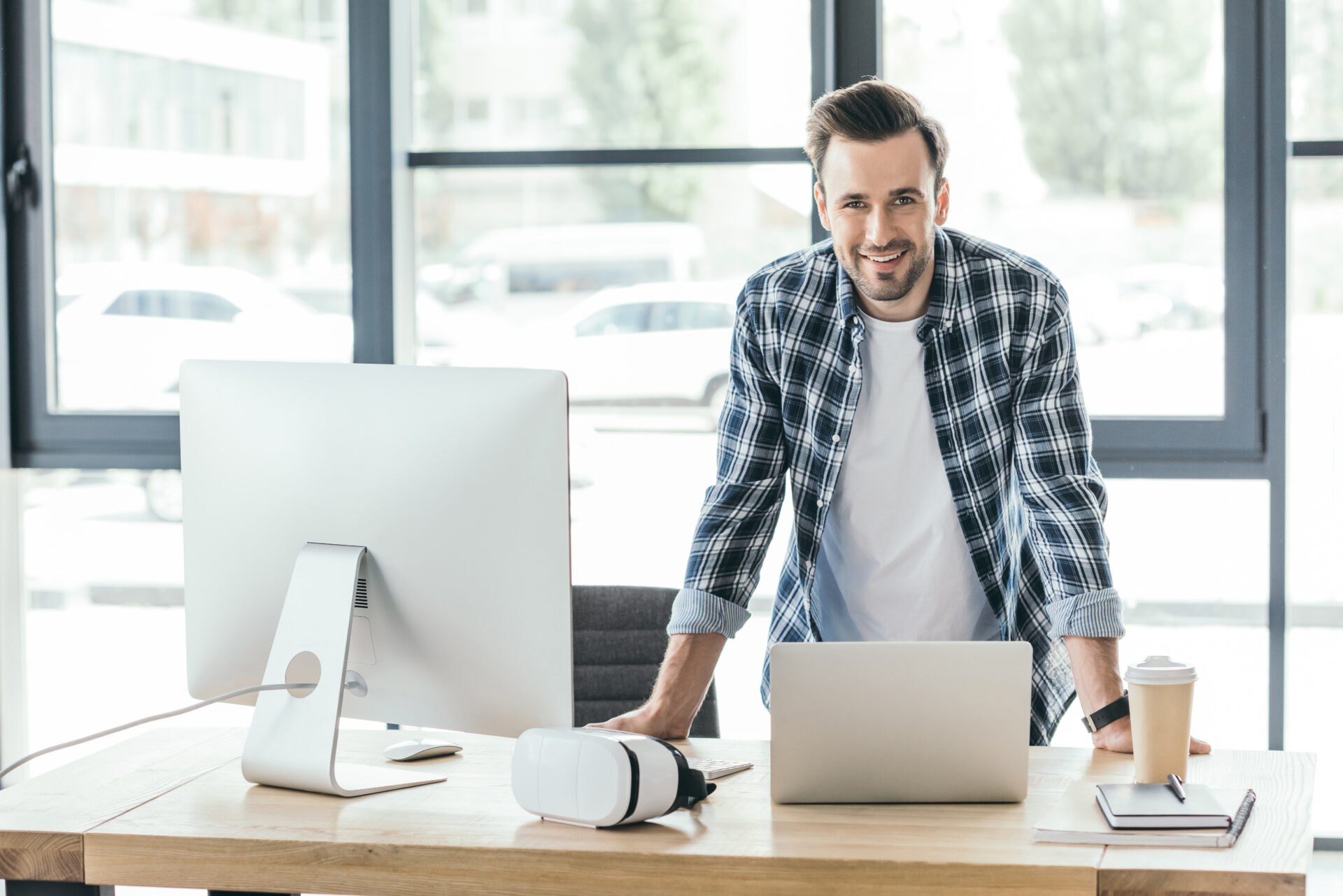 young-man-smiling-at-camera-while-leaning-at-table